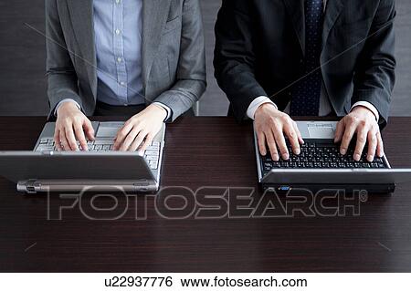 Stock Photograph - Businesspeople using laptop. Fotosearch