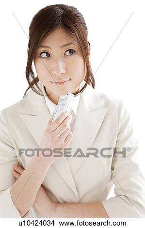 Picture - Businesswoman holding a cell phone and thinking. Fotosearch