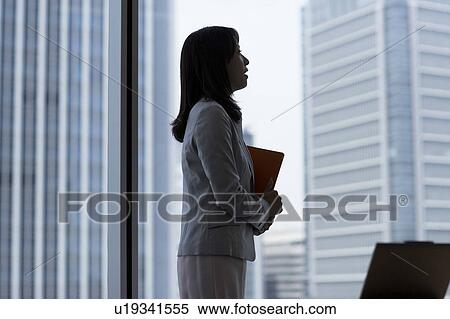 Stock Photography - Businesswoman holding a ring binder. Fotosearch