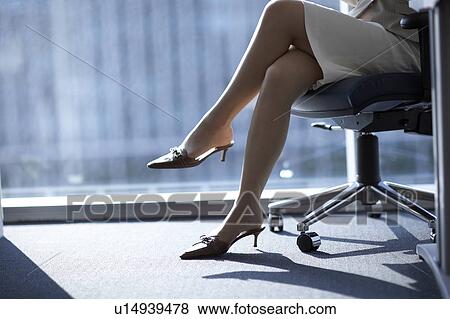 Stock Photo - Businesswoman sitting on chair, low section. Fotosearch