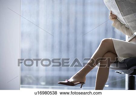 Stock Photo - Businesswoman sitting on chair, low section. Fotosearch