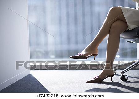Businesswoman sitting on chair, low section View Large Photo Image Stock Photo - Businesswoman sitting on chair, low section. Fotosearch