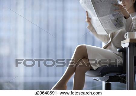 Stock Image - Businesswoman sitting on chair, midsection. Fotosearch