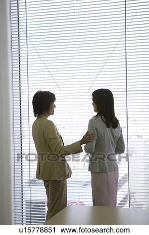 Businesswomen talking by the window View Large Photo Image Stock Image - Businesswomen talking by the window. Fotosearch