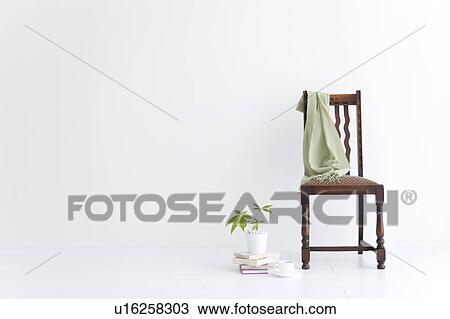 Stock Image - Chair, pashmina, books, coffee cup, and house plant. Fotosearch