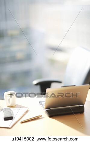 Stock Image - Desk in office with laptop. Fotosearch