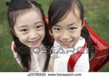 Stock Image - Elementary schoolgirls looking at camera. Fotosearch