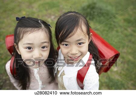 Stock Image - Elementary schoolgirls looking at camera. Fotosearch