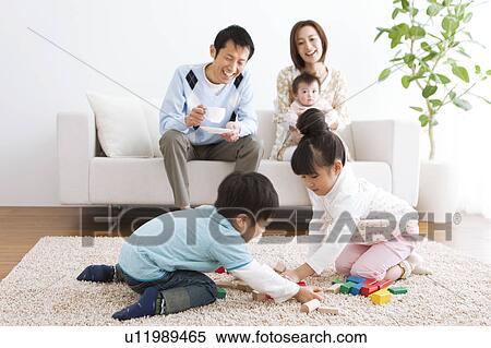 Family playing in living room View Large Photo Image Stock Photography - Family playing in living room. Fotosearch