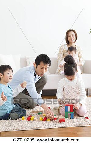Stock Photography - Family playing in living room. Fotosearch