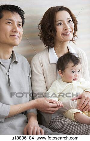 Picture - Family sitting on hardwood floor. Fotosearch