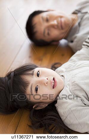 Father and daughter lying on back on hardwood floor View Large Photo Image Stock Image - Father and daughter lying on back on hardwood floor. Fotosearch