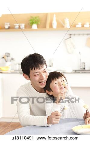 Stock Image - Father and son eating apple. Fotosearch