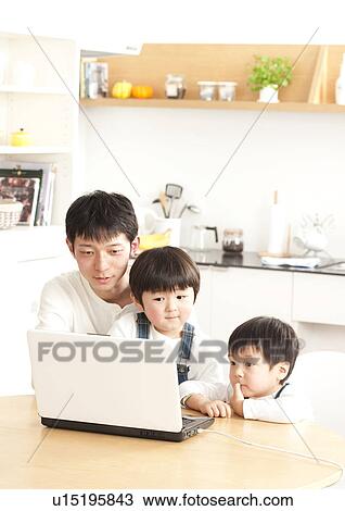 Stock Image - Father and sons using laptop. Fotosearch