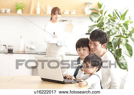 Stock Photo - Father and sons using laptop. Fotosearch