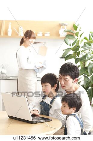 Stock Photograph - Father and sons using laptop. Fotosearch