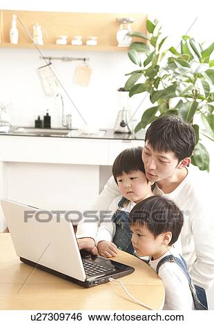 Stock Photograph - Father and sons using laptop. Fotosearch