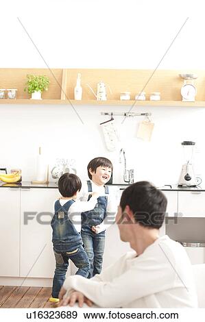 Father looking at sons playing in the kitchen View Large Photo Image Stock Photo - Father looking at sons playing in the kitchen. Fotosearch