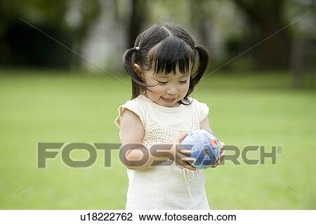 Stock Image - Girl holding a ball. Fotosearch