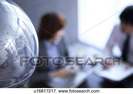 Globe and businesspeople having a meeting View Large Photo Image Stock Photo - Globe and businesspeople having a meeting. Fotosearch