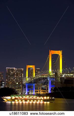 Stock Image - Illuminated Boat and Rainbow Bridge. Fotosearch