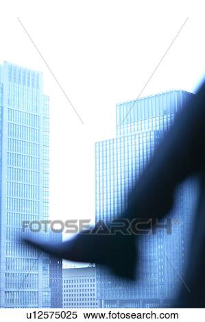 Stock Photography - Legs of businessman and office buildings in background. Fotosearch