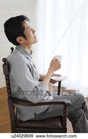 Man with legs crossed at knee holding coffee View Large Photo Image Stock Photo - Man with legs crossed at knee holding coffee. Fotosearch
