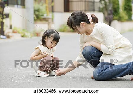 Stock Photograph - Mother and daughter playing on the street. Fotosearch