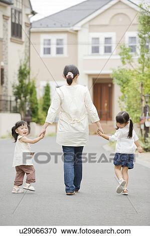 Mother and daughters holding hands and walking View Large Photo Image Stock Image - Mother and daughters holding hands and walking. Fotosearch