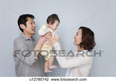 Mother and Father carrying baby View Large Photo Image Stock Image - Mother and Father carrying baby. Fotosearch