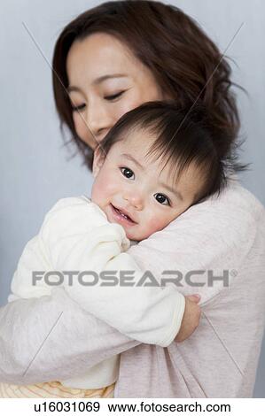 Stock Photo - Mother carrying a baby girl. Fotosearch