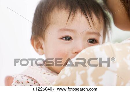 Stock Photo - Mother carrying a crying baby . Fotosearch