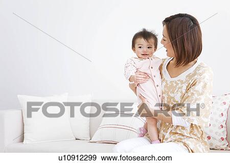 Stock Photo - Mother carrying baby . Fotosearch