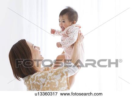 Stock Photo - Mother lifting baby. Fotosearch