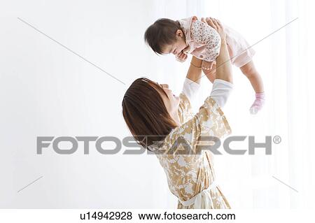 Stock Photo - Mother lifting baby. Fotosearch