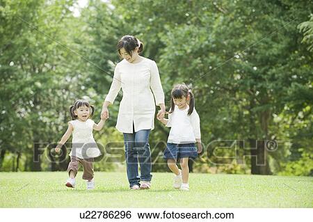 Stock Photograph - Mother walking in park with kids . Fotosearch