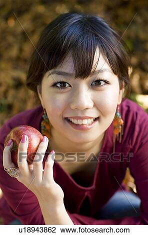 Stock Image - Portrait of Young Woman with Apple. Fotosearch