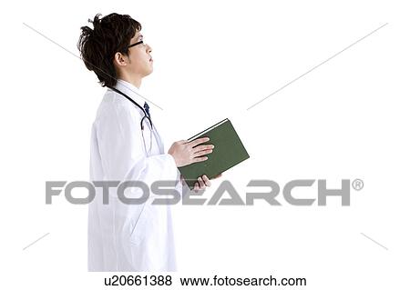 Stock Photo - Profile of young male doctor holding a book. Fotosearch