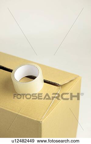 Stock Photo - Roll of Tape on Cardboard Box. Fotosearch