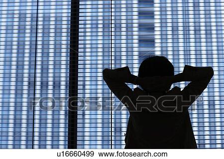 Silhouette of businesswoman standing by window View Large Photo Image Stock Photo - Silhouette of businesswoman standing by window. Fotosearch