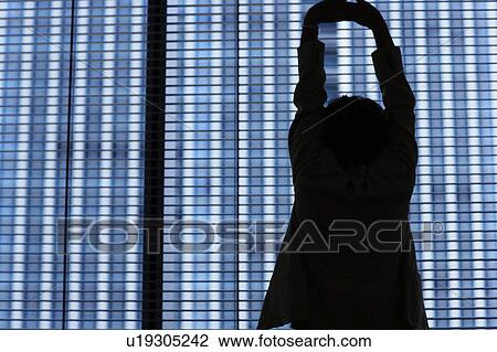 Silhouette of businesswoman stretching by window View Large Photo Image Stock Image - Silhouette of businesswoman stretching by window. Fotosearch