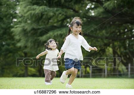 Stock Photograph - Sisters playing in the Park. Fotosearch
