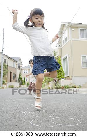 Stock Photo - Sisters playing on the street. Fotosearch