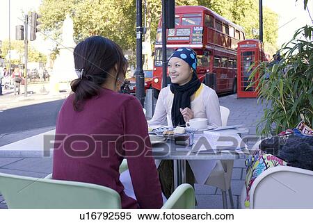 Stock Photography - Two Young Women Having Lunch at Cafe. Fotosearch