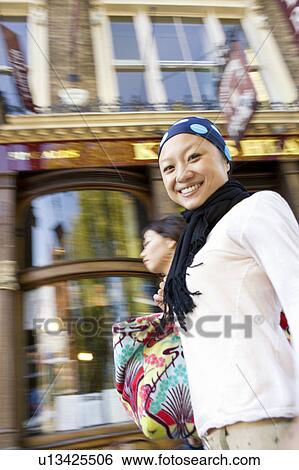 Stock Photograph - Two Young Women Walking Past Pub. Fotosearch