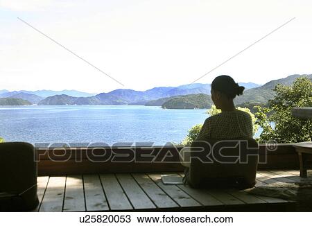 Stock Image - Woman Looking at Tranquil Seascape. Fotosearch