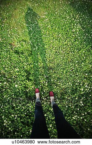 Stock Image - Woman Standing on Grass, Low Section View. Fotosearch
