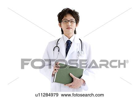 Young male doctor holding a book View Large Photo Image Stock Photo - Young male doctor holding a book. Fotosearch