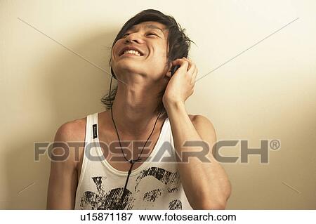 Stock Photo - Young man listening to music. Fotosearch