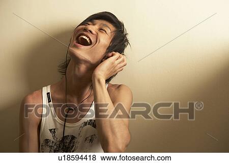 Stock Photo - Young man singing to music. Fotosearch